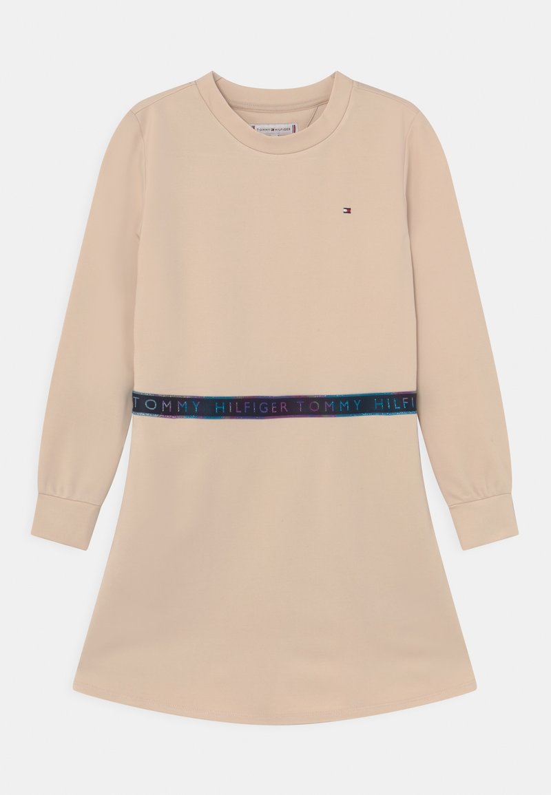 Beżowa sukienka z długim rękawem, prosta podstawa i granatowy pas z napisem "TOMMY HILFIGER" w wielokolorowym tekście. Miękka tkanina.