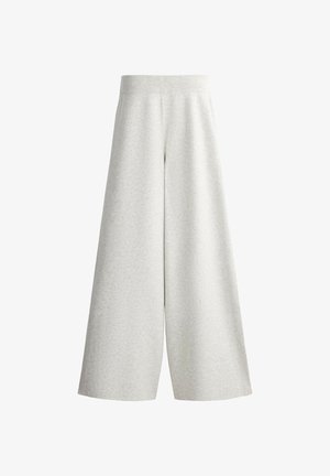 Pantalon large en maille gris clair avec une taille élastique côtelée et des détails sur les panneaux latéraux, présenté sur fond blanc.