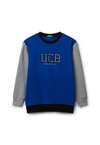 Felpa blu con maniche grigie, caratterizzata da un logo "UCB" in nero e grigio e dalla scritta "ESTABLISHED 1965". Collo e orlo a costine neri.