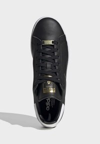 Schwarze Ledersneaker mit goldenen Akzenten und weißer Sohle. Verfügt über eine runde Zehenpartie, Schnürdesign und strukturierte Oberfläche.