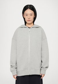 Grijze rits-hoodie met capuchon, oversized pasvorm, geribbelde manchetten en zoom, gemaakt van zachte stof, met een rits aan de voorkant.