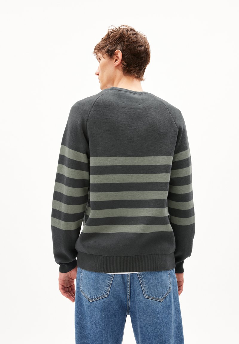 Dunkelgrauer Pullover mit horizontalen olivgrünen Streifen, strukturiertem Strickstoff, Rundhalsausschnitt sowie gerippten Bündchen und Saum, kombiniert mit blauen Jeans.