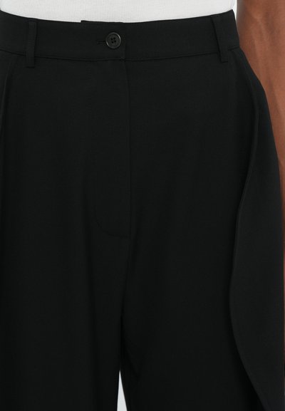 Black trousers made of smooth fabric, featuring a button closure, front pleats, and side pockets with a tailored fit design.
