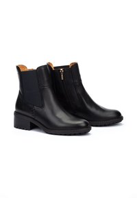 Bottines en cuir noir avec panneaux élastiques sur les côtés, détail de fermeture éclair doré et semelle en caoutchouc texturée. Talon bloc pour plus de stabilité.