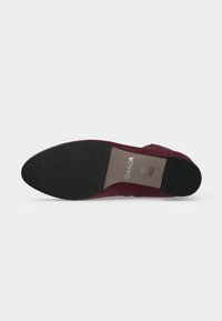 Semelle d'une chaussure pointue rouge foncé avec des protections noires à l'avant et au talon, étiquetée "Gabor", taille 4,5, fabriquée au Portugal.