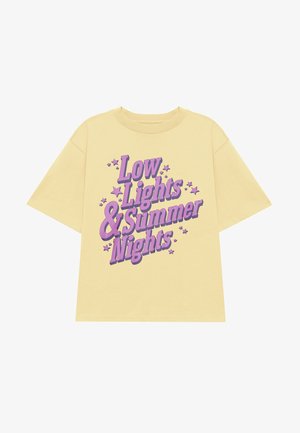 Gul bomulds T-shirt med korte ærmer, med lilla grafisk tekst: "Low Lights & Summer Nights" med stjernedetaljer.