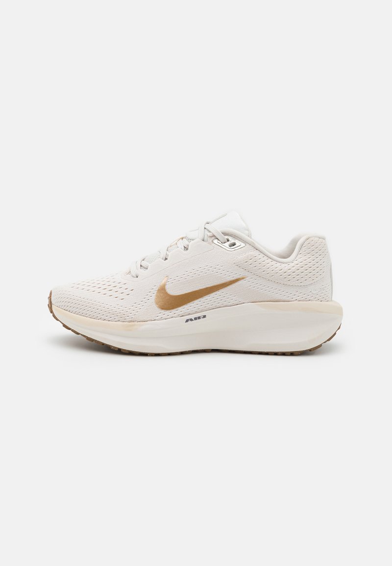White athletic shoe with a breathable mesh upper, gold swoosh logo, padded collar, and a cushioned sole for support and comfort.