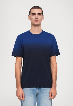 Tumedan sinise värvi crew-neck t-särk, mis on valmistatud pehmest puuvillast, lühikeste varrukatega ja mugava lõikega, koos helesiniste teksast pükstega.