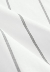 Weißer Stoff mit horizontalen grauen Streifen, der eine glatte Textur und ein leicht glänzendes Finish aufweist, angeordnet in einem diagonal überlappenden Muster.