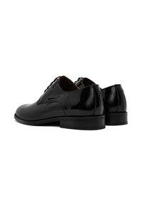 Chaussures habillées en cuir verni noir avec un bout arrondi, un lacet à l'avant et un talon bas. Fini lisse avec des accents minimaux.