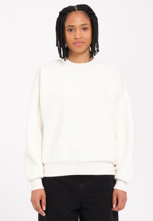 Felpa bianca in fleece con scollo rotondo, polsini e fondo a costine, e un piccolo logo ricamato sul petto. Tessuto morbido, vestibilità rilassata.