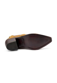 Zapato de ante marrón con una suela de cuero texturizado, punta afilada y costuras decorativas. Presenta un tacón plano y ligeramente curvado.