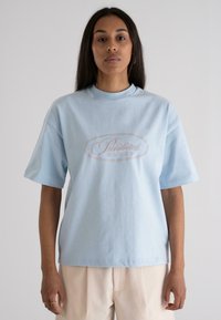 Light blue cotton t-shirt with short sleeves, featuring a pink "Prohibited" graphic in an oval design at the center.