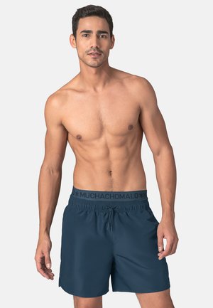 Pantaloni da bagno blu navy realizzati in tessuto leggero, con una vita regolabile tramite cordoncino e una fascia con logo, caratterizzati da una linea dritta e una texture liscia.
