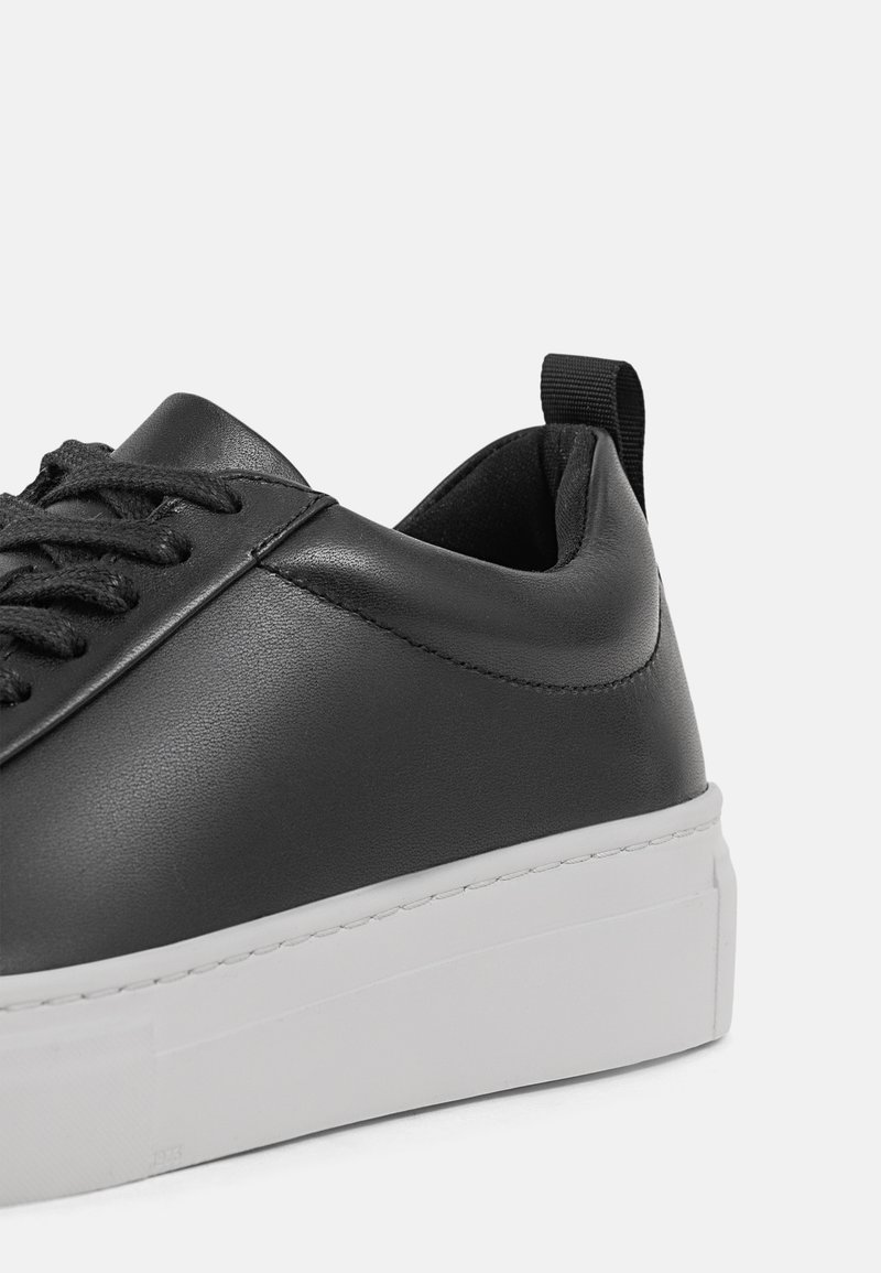 Schwarze Ledersneaker mit glatter Oberfläche, ausgestattet mit einer weißen Gummisohle, strukturierten Schnürsenkeln und einer Fersenlasche für ein einfaches Anziehen.