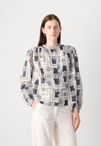 Blusa button-up in tessuto stampato con tonalità blu navy, bianco e verde. Maniche a puff con dettagli arricciati e polsini aderenti.