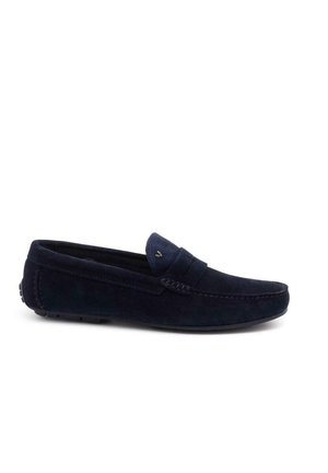 Mocasines de ante azul marino con costura, suela de goma plana y punta redondeada. Presentan una correa decorativa en la parte superior.