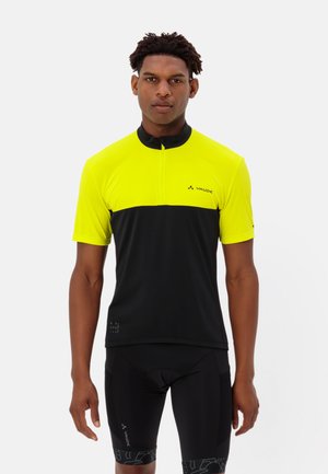 Gelb-schwarz gestreiftes Radtrikot mit kurzen Ärmeln, halbmondförmigem Reißverschluss und figurbetontem Design, kombiniert mit schwarzen Radhosen mit gemusterten Akzenten.