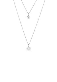 Deux colliers en argent avec des pendentifs ronds en diamant clair. Le pendentif supérieur est plus petit et plus simple que le pendentif inférieur.