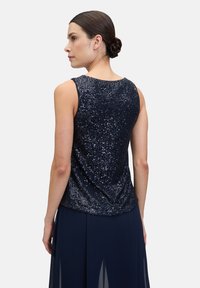 Top sans manches bleu marine avec une surface pailletée et une texture douce, conçu avec un léger drapé à l'arrière et un col rond.