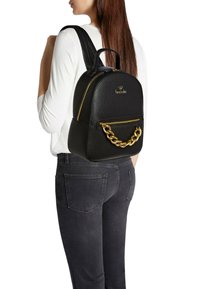Zaino in ecopelle nera dalla forma arrotondata, con rifiniture dorate e un dettaglio a catena; dotato di due spallacci regolabili e una tasca con cerniera.