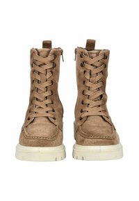 Botas de tobillo de ante color marrón con cordones en la parte delantera, cremalleras laterales y una suela gruesa de goma blanca. Detalles de costura en la zona de los dedos.