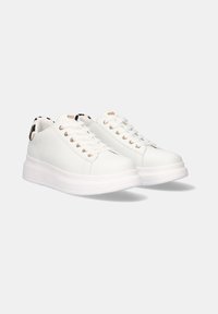 Zapatillas sintéticas blancas con un acabado suave, punta redondeada, diseño de cordones y ojales dorados. Cuenta con una suela de plataforma blanca.