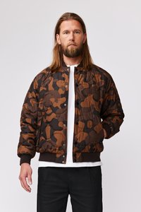 Brun camo pufferjakke med quiltet tekstur, trykknaplukning, ribbede manchetter og et ensfarvet basislag.
