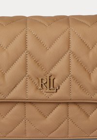 Pintų rudų rankinės su zigzagu, su auksinės spalvos detalėmis ir akcentuotu "RL" logotipu priekyje.