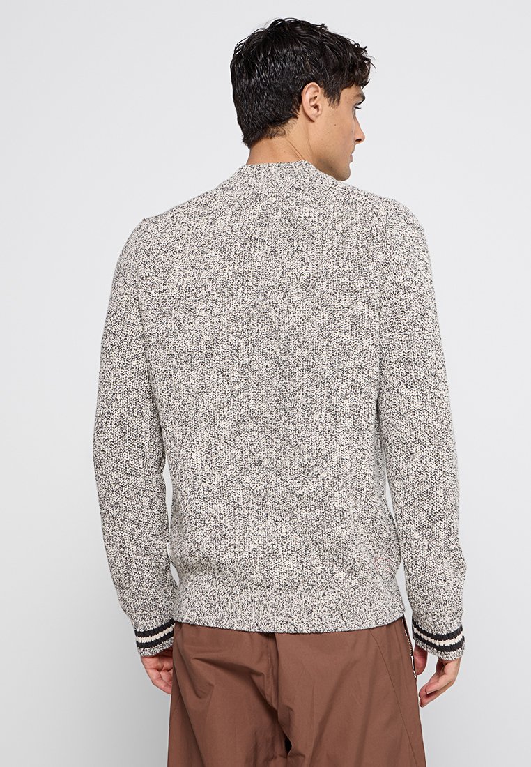 Pull en tricot avec un motif texturé gris et blanc, présentant un col rond et des accents rayés sur les poignets. Vue arrière montrée.