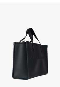 Sac fourre-tout noir en matière lisse, avec un logo embossé à l'avant, une forme structurée et deux anses supérieures.