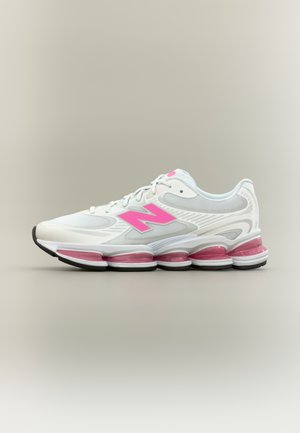 Scarpa sportiva bianca con dettagli e logo rosa, tomaia in mesh texturizzato, intersuola ammortizzata e cinque camere d'aria visibili al tallone.