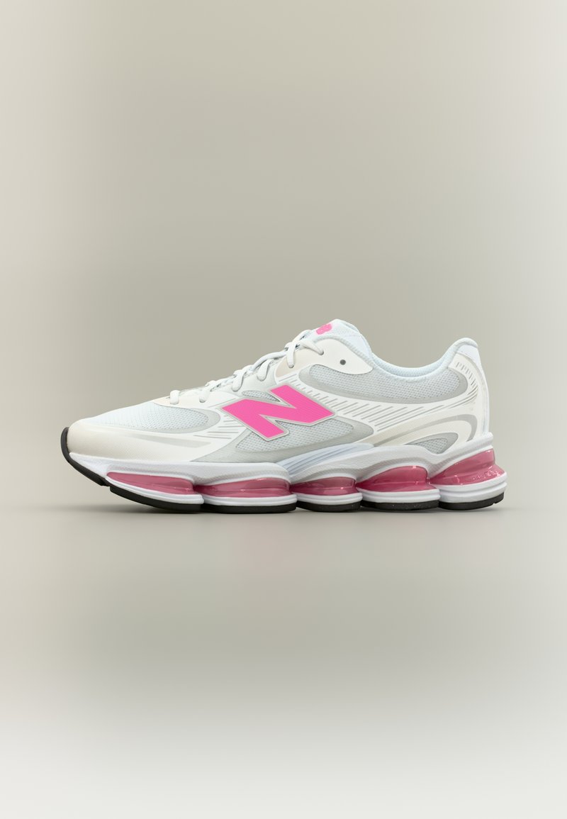 Chaussure de sport blanche avec des accents roses et un logo, une tige en mesh texturé, une semelle intermédiaire rembourrée, et cinq chambres d'air visibles au niveau du talon.