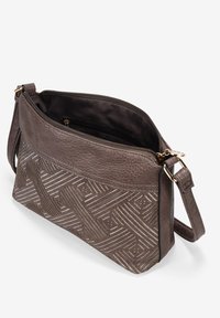 Bolso bandolera de cuero en marrón oscuro con patrón en relieve diagonal. Cuenta con un cierre con cremallera y una correa ajustable. El interior incluye bolsillos.