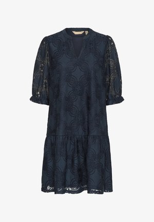 Marineblauwe kanten jurk met een V-hals, korte pofmouwen en een gelaagde ruffle zoom. Een bloemenpatroon bedekt de stof, wat textuur toevoegt.