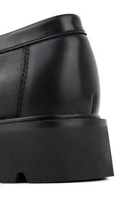 Czarne skórzane buty na grubej platformie, z gładką teksturą i wyraźnym szwem wzdłuż szwów. Akcentowane w okolicy pięty.