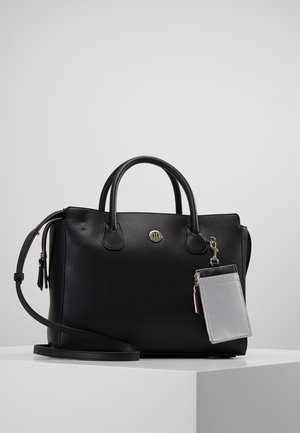 Black leather handbag with double handles, detachable shoulder strap, and a small gray cardholder attached by a gold clasp.