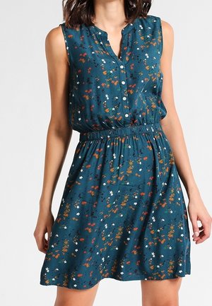 Robe sans manches bleu sarcelle avec taille élastique, boutonnée sur le devant et petit motif floral dispersé orange, blanc et noir.