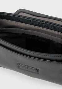 Γκρι δερμάτινη τσάντα με υφασμάτινη, υφή, διαθέτει φερμουάρ κλεισίματος και μαλακή υφασμάτινη επένδυση. Στο εσωτερικό περιλαμβάνει μαύρη θήκη για κάρτες.