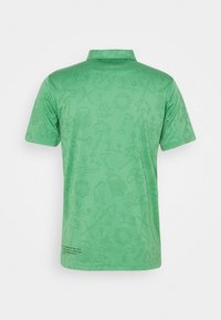 Polo vert avec un motif texturé comprenant des palmiers, des bières et des animaux. Col classique et manches courtes. Design subtil.
