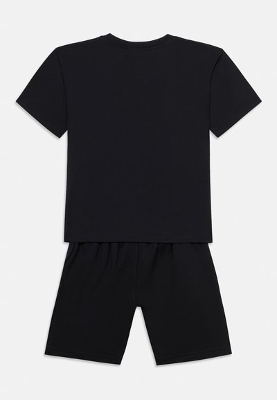 Σετ με μαύρο T-shirt κοντομάνικο και σορτς με ελαστική μέση που ταιριάζουν, απλωμένα επίπεδα με την πίσω πλευρά να φαίνεται σε λευκό φόντο.