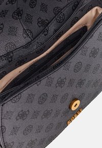 Borsa nera in tessuto con motivo logo embossato, scomparti con zip e accessori in metallo dorato. Interno di colore beige chiaro.