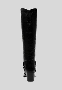 Stivale in pelle nera alta fino al ginocchio con punta leggermente appuntita, bordo superiore curvato e una cintura decorativa con accenti metallici alla caviglia.