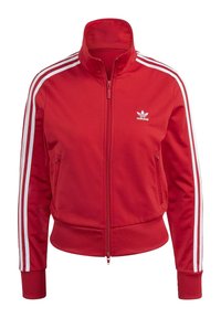 Czerwona kurtka na zamek z wysokim kołnierzem, białe paski po bokach, ściągacze na mankietach i w pasie. Na piersi haftowane logo.