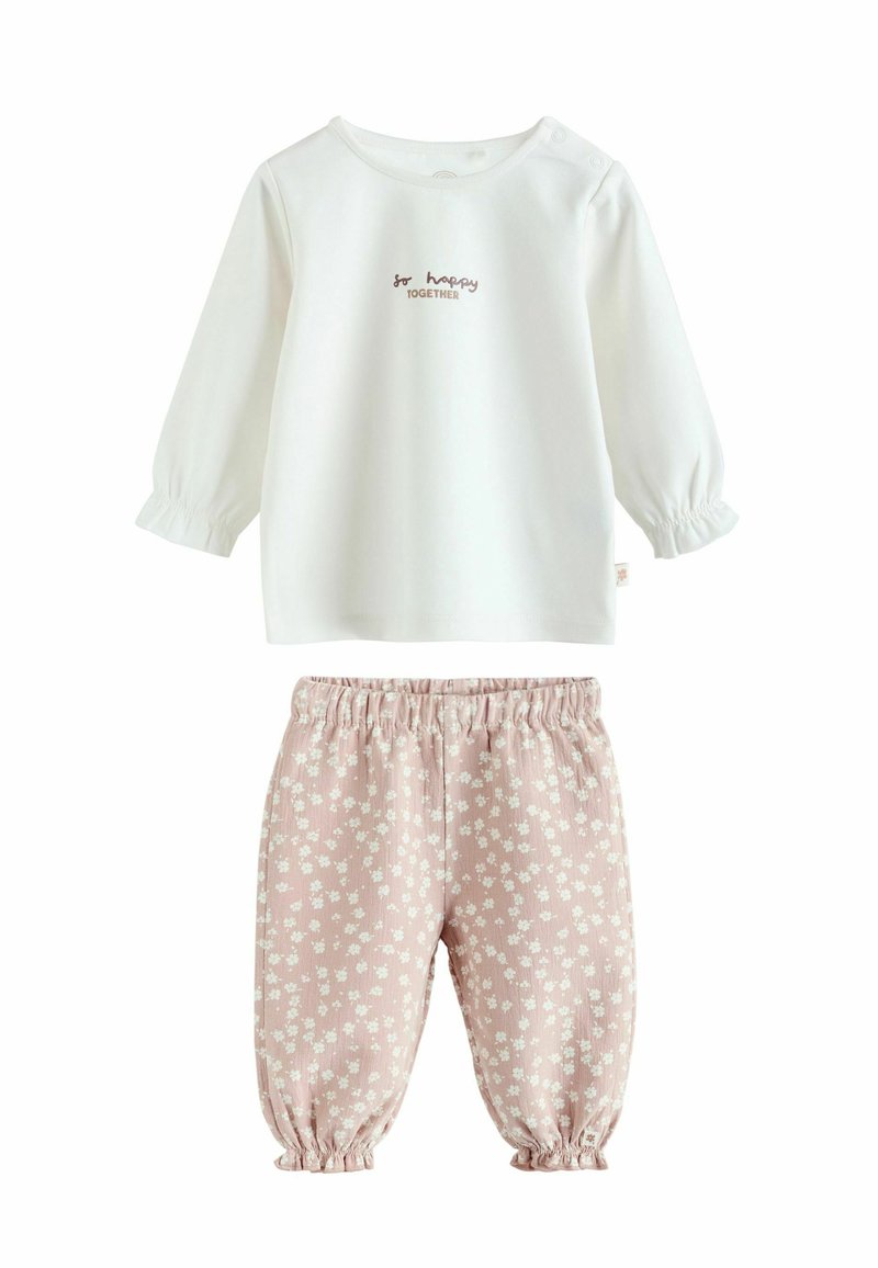 Weißes Langarmoberteil mit gerafften Ärmeln und einem braunen Druck "So Happy Together", kombiniert mit rosa, floral gemusterten Hosen mit elastischen Bündchen.