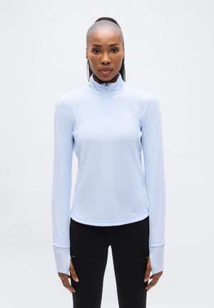 Bluza sportivă albastru deschis cu mâneci lungi, guler înalt și fermoar pe jumătate, realizată dintr-un material texturat și cu logo detaliat pe piept.