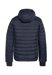 Marineblå termojakke med hætte, der har quiltet design, ribstrikkede manchetter og en glat, skinnende overflade. Billedet viser jakken bagfra med fokus på hætten og sømdetaljer.