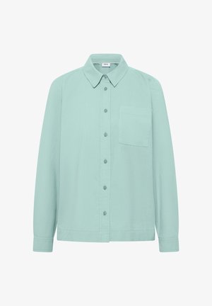 Chemise à manches longues vert clair avec col pointu et une poche poitrine, présentée sur un fond blanc.