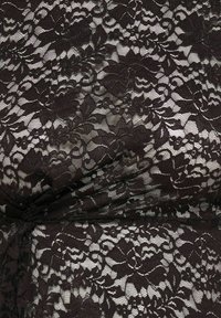 Sort blomstret blonderstof med indviklede blad- og blomsterdesigns over en lys baggrund, der viser tekstur og fine stingdetaljer.