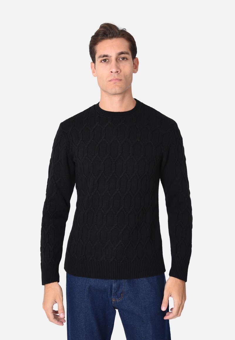 Maglione nero lavorato a maglia con un motivo testurizzato, colletto rotondo e maniche lunghe, abbinato a jeans di denim blu.
